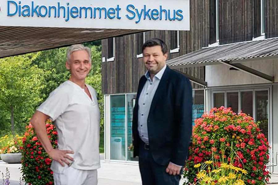 To menn som står foran en bygning