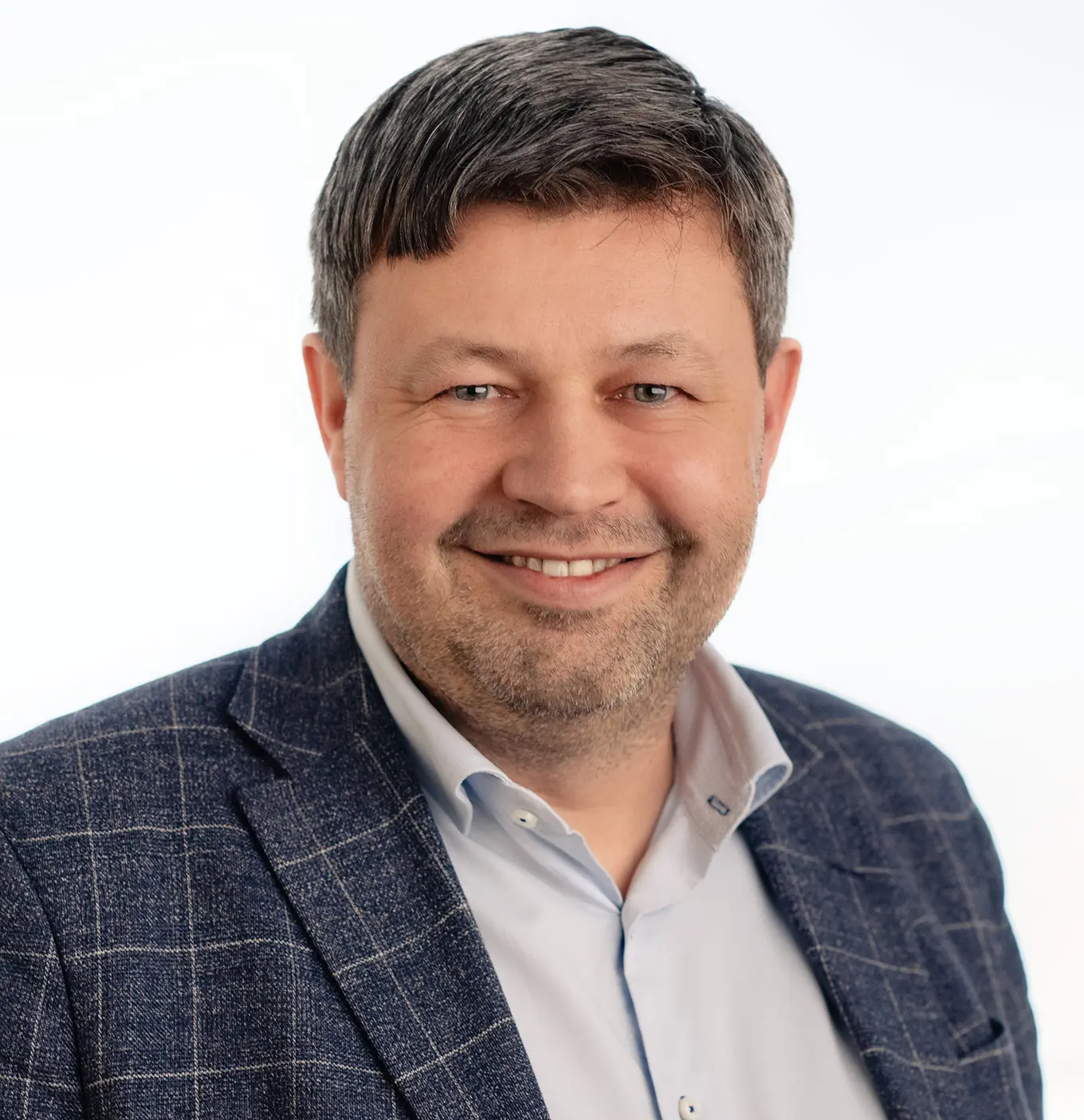 En mann som smiler til kameraet