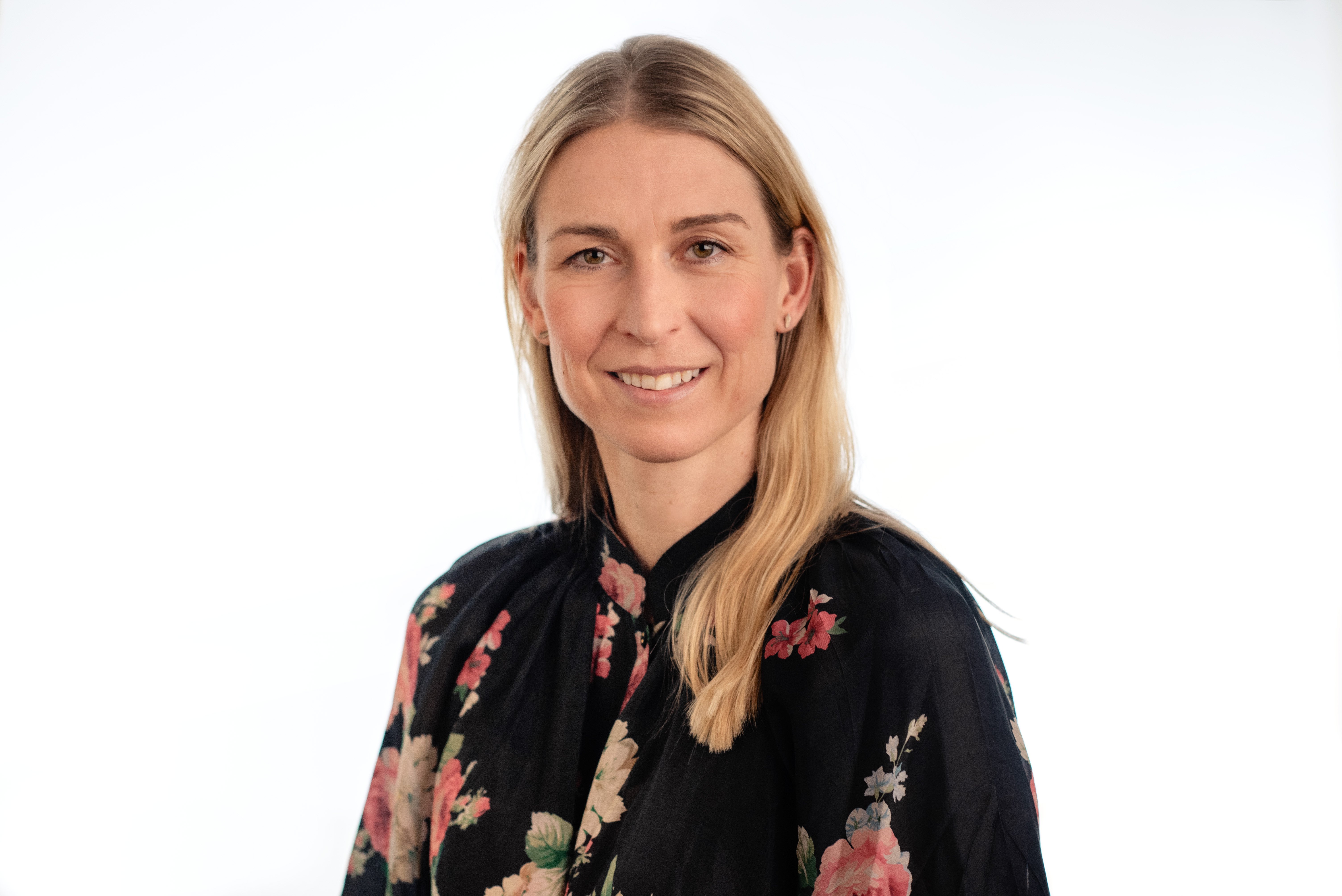 En kvinne som smiler til kameraet