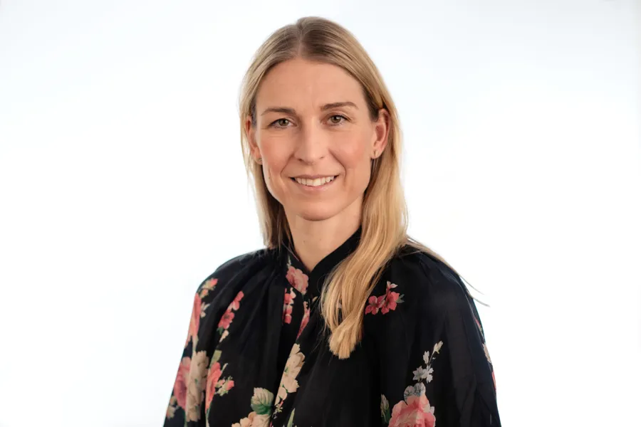 En kvinne som smiler til kameraet