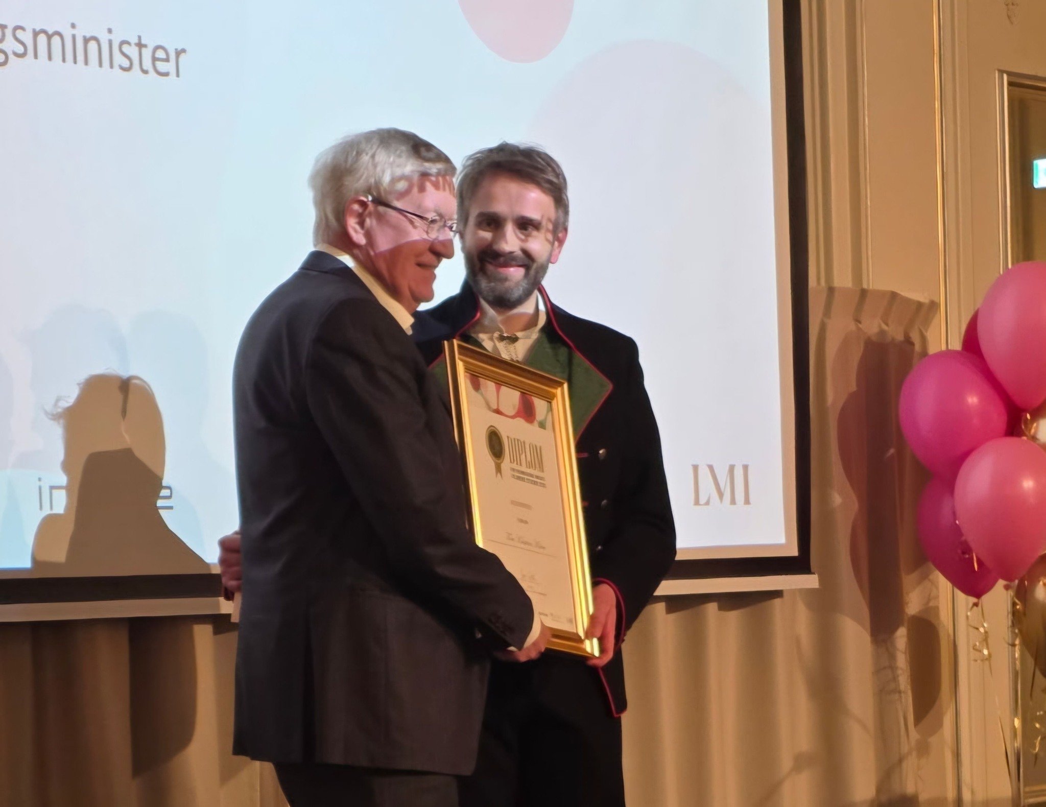 En mann som holder en plakett ved siden av en mann som holder en plakett