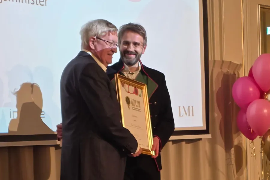 En mann som holder en plakett ved siden av en mann som holder en plakett