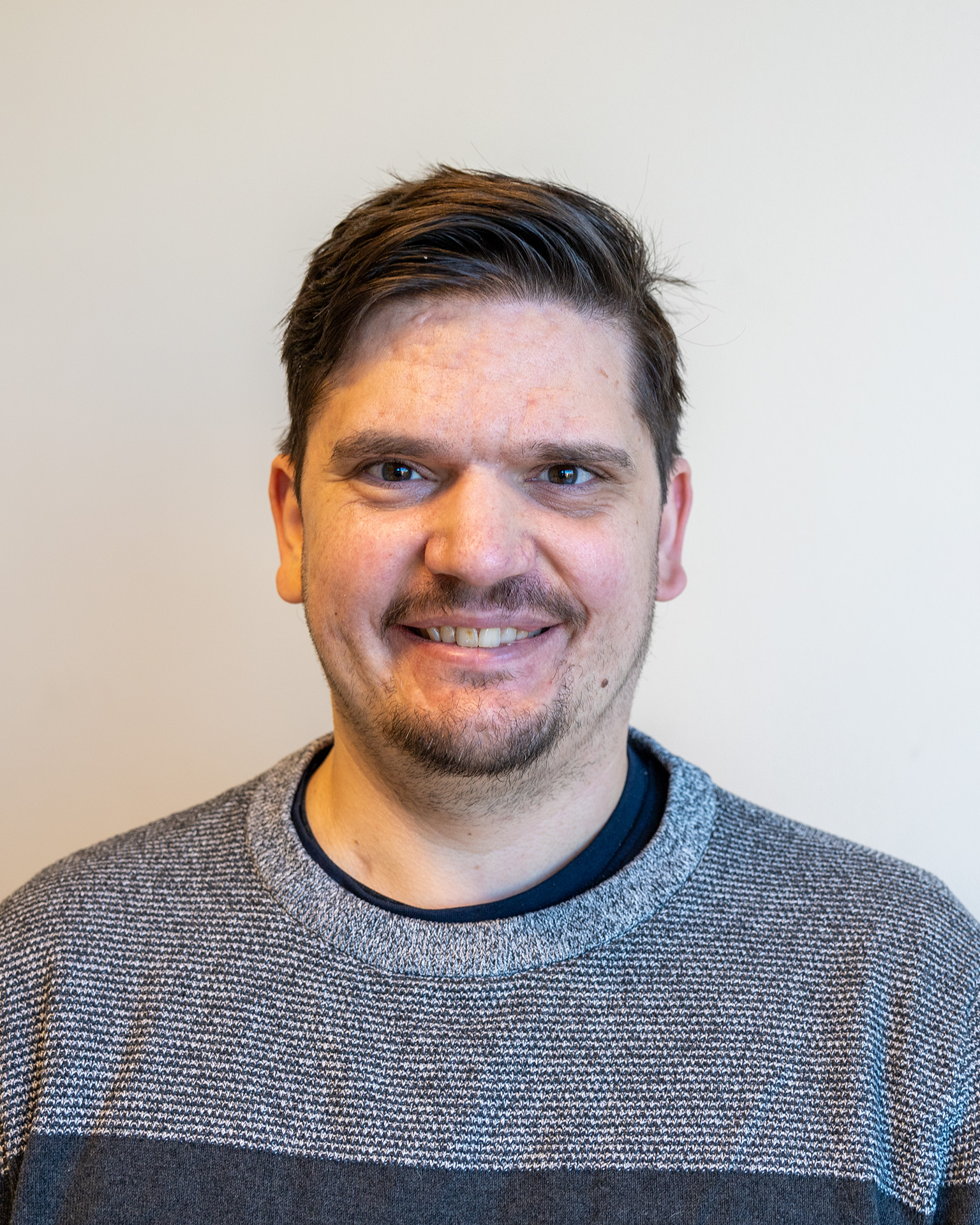 En mann som smiler til kameraet