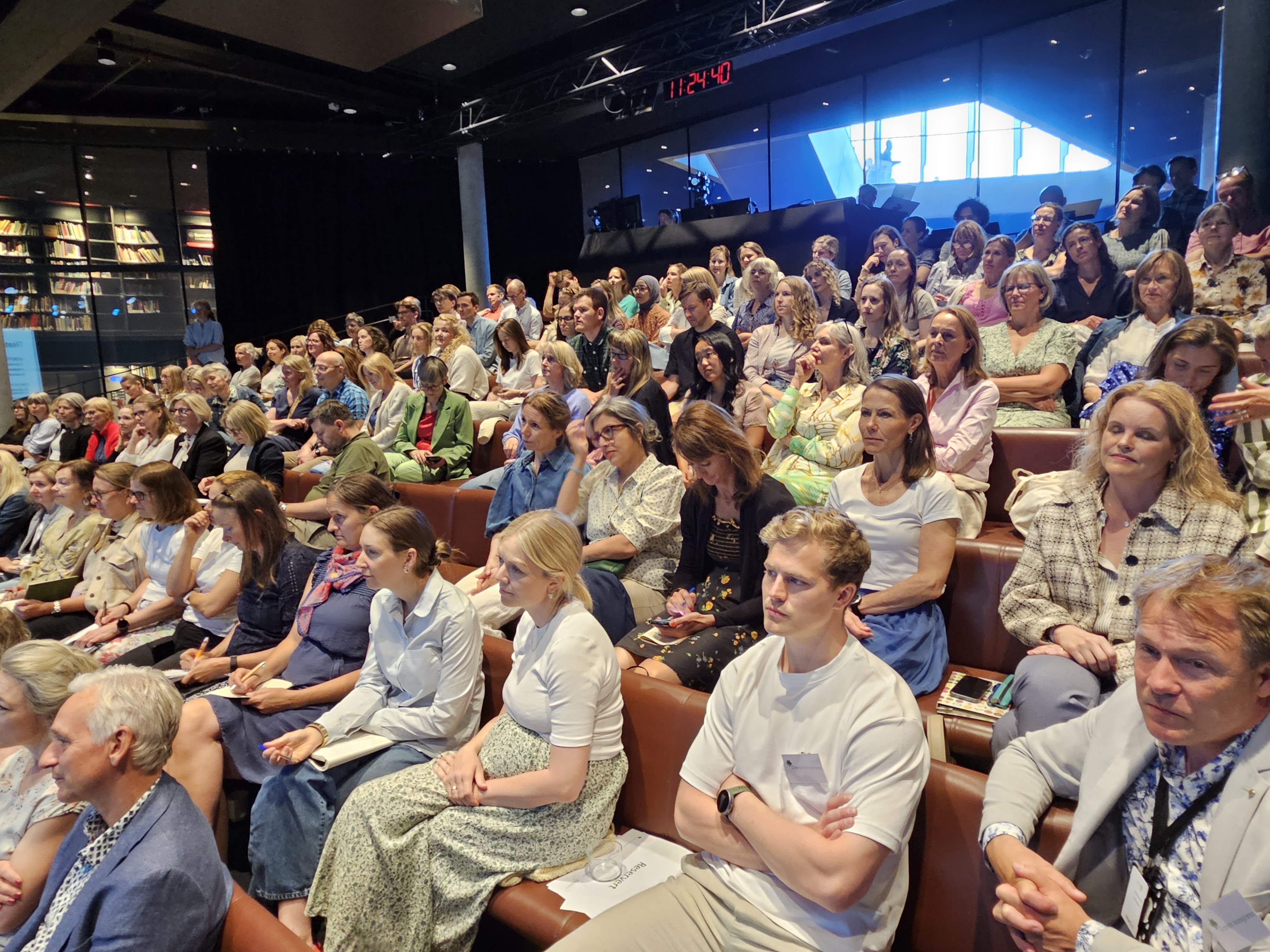 En stor gruppe mennesker som sitter i et rom