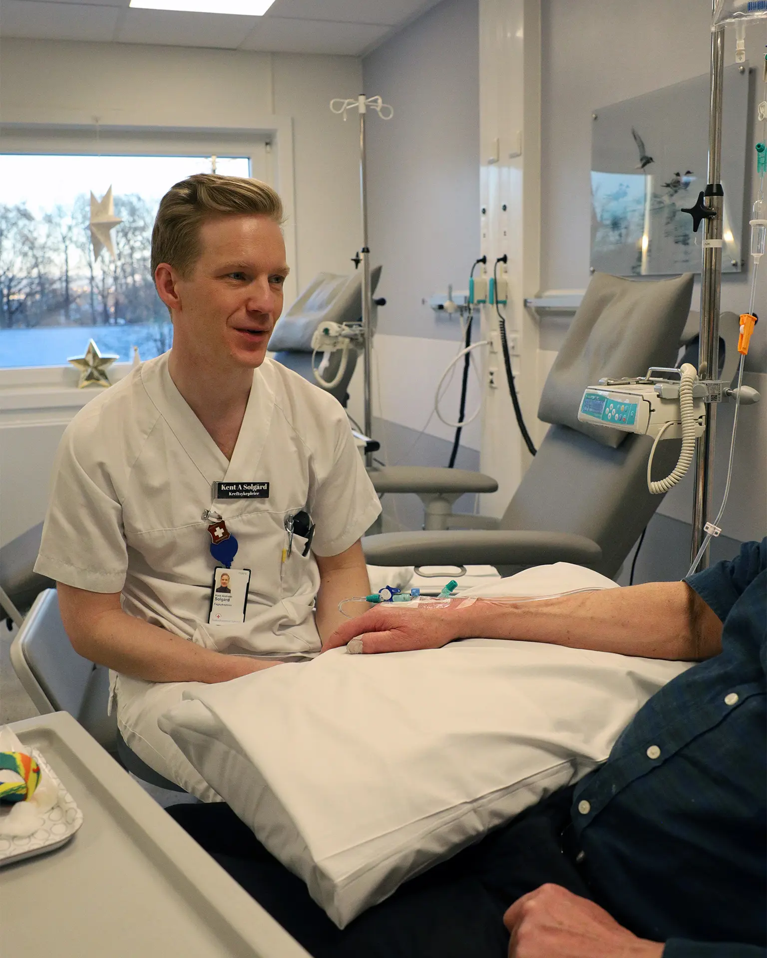 En mann som sitter i en sykehusseng