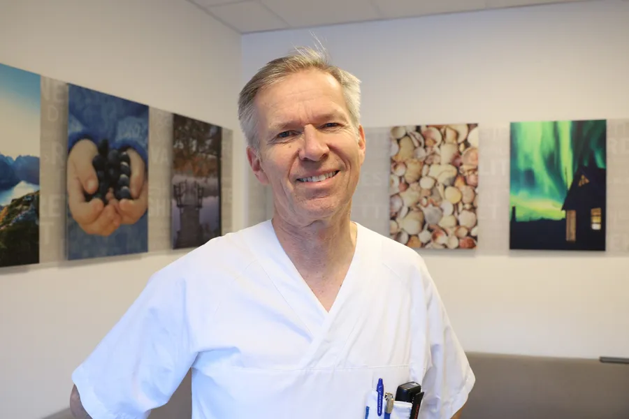 En mann som står foran en vegg av malerier