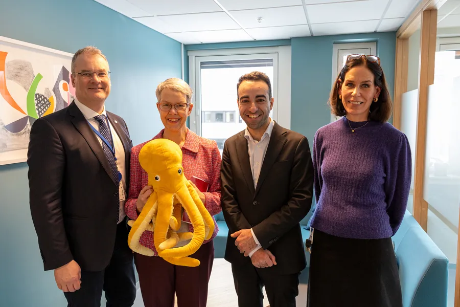 En gruppe mennesker som poserer med et kosedyr