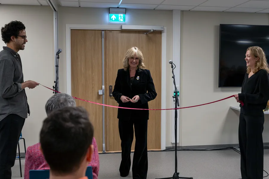 En person som står foran et podium med en mikrofon foran en gruppe mennesker