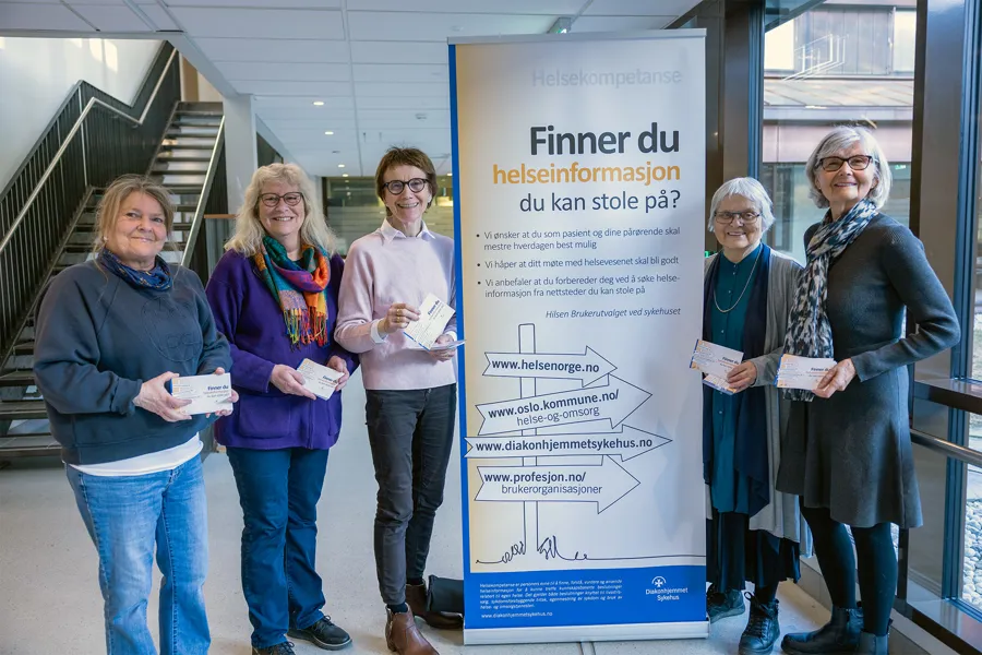 En gruppe kvinner som står ved siden av et skilt