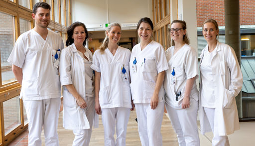 En gruppe mennesker iført hvite laboratoriefrakker