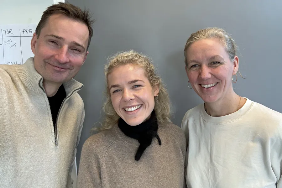 En gruppe mennesker som smiler