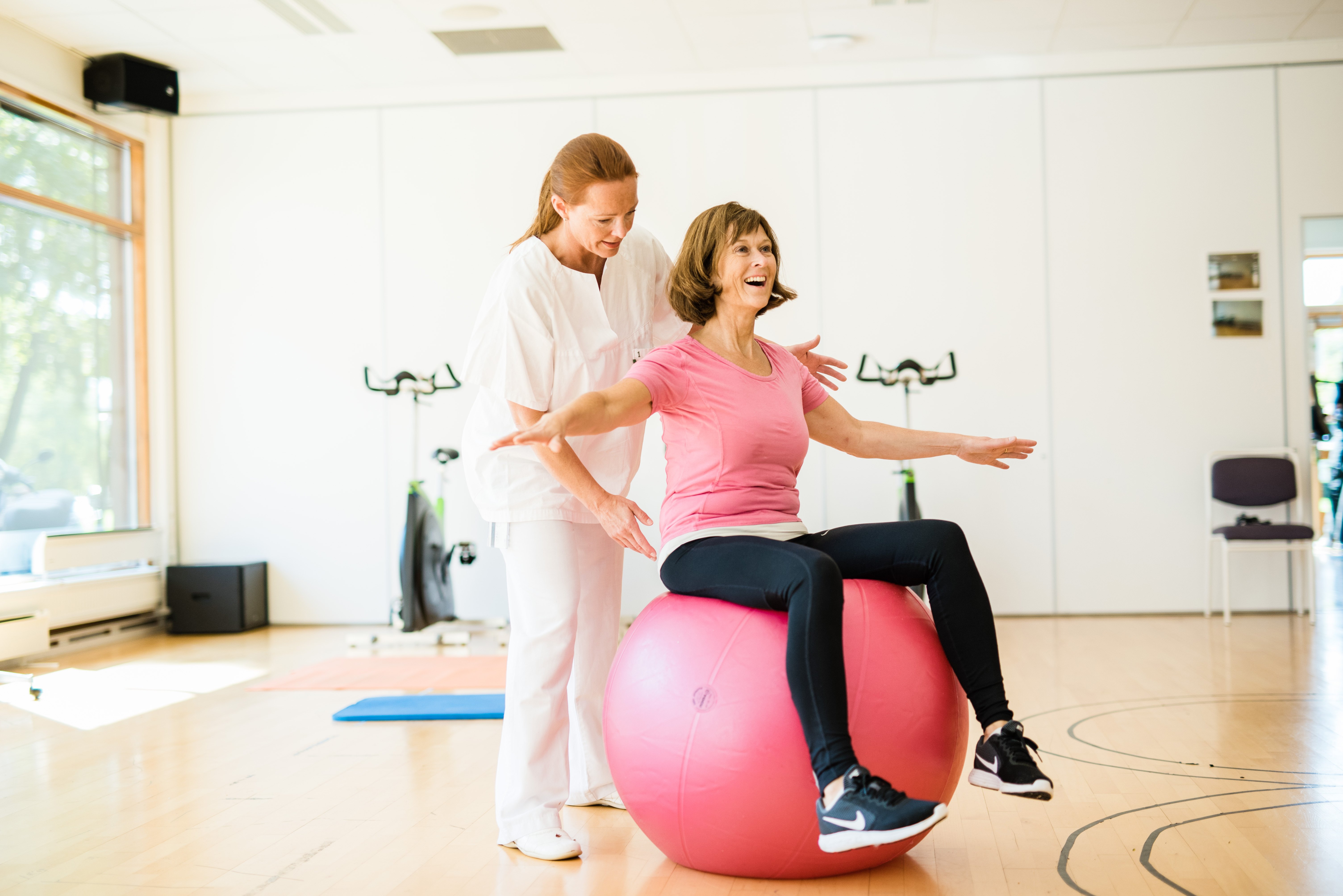 To kvinner og en ball den ene av dem sitter på