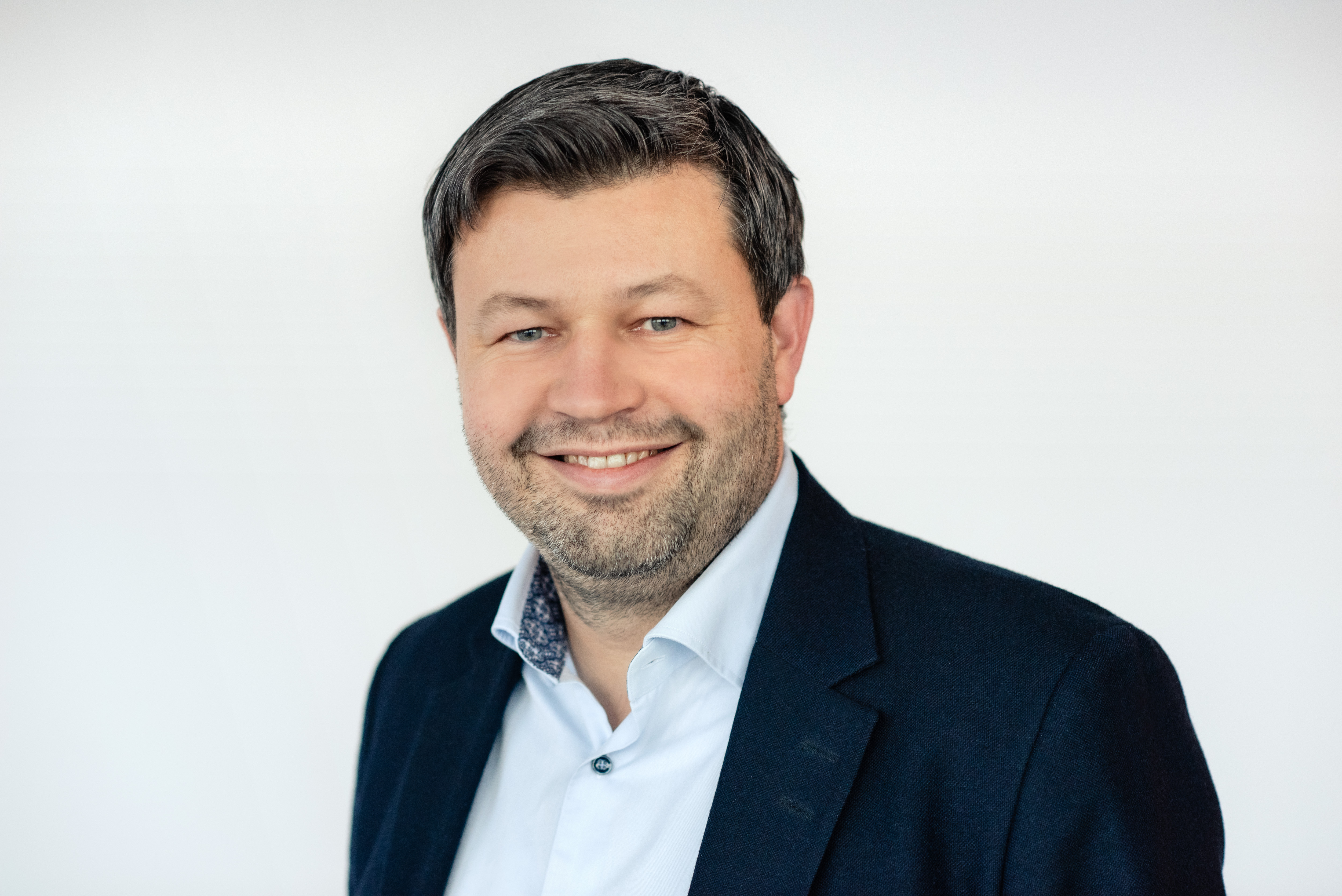 En mann som smiler til kameraet