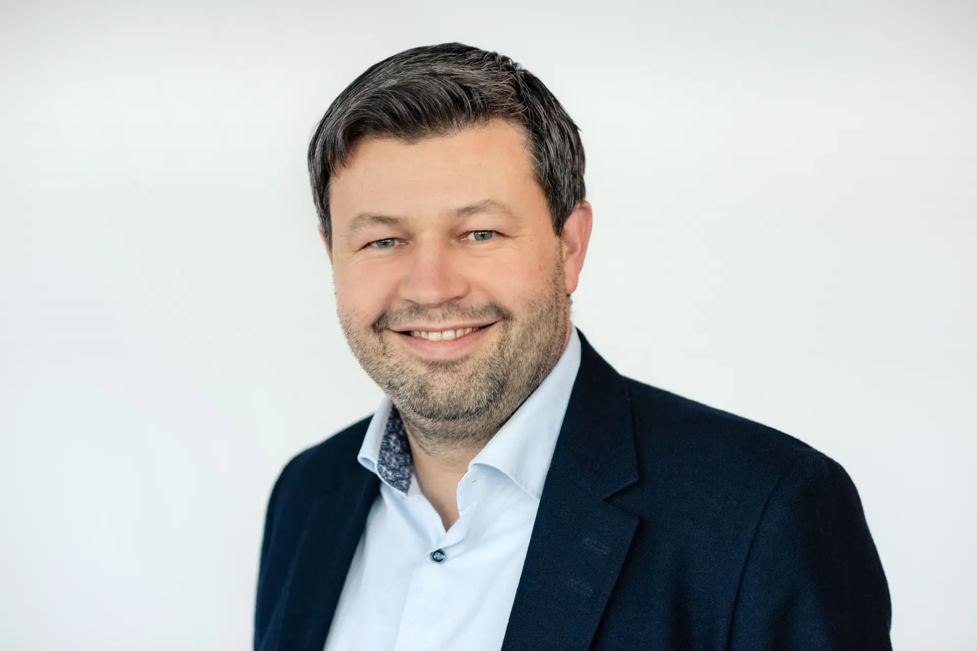 En mann som smiler til kameraet