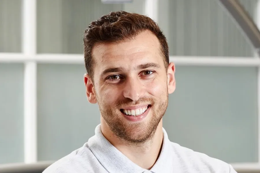 En mann som smiler til kameraet