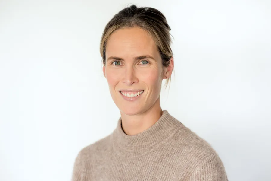 En kvinne som smiler til kameraet