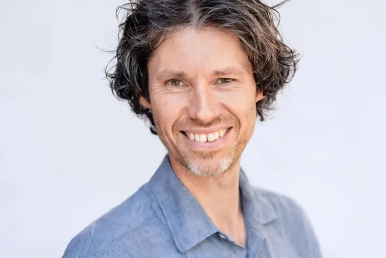 En mann med skjegg som smiler
