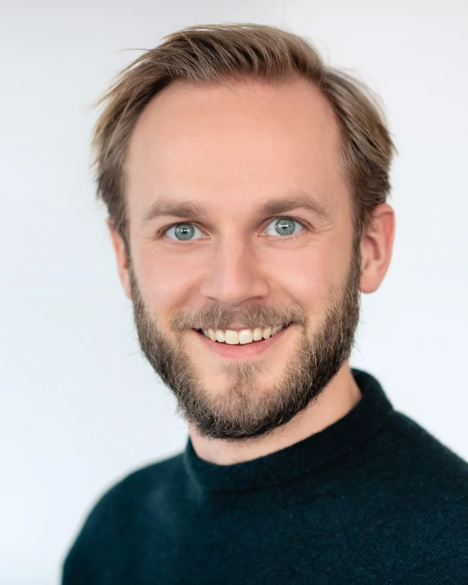 En mann med skjegg som smiler