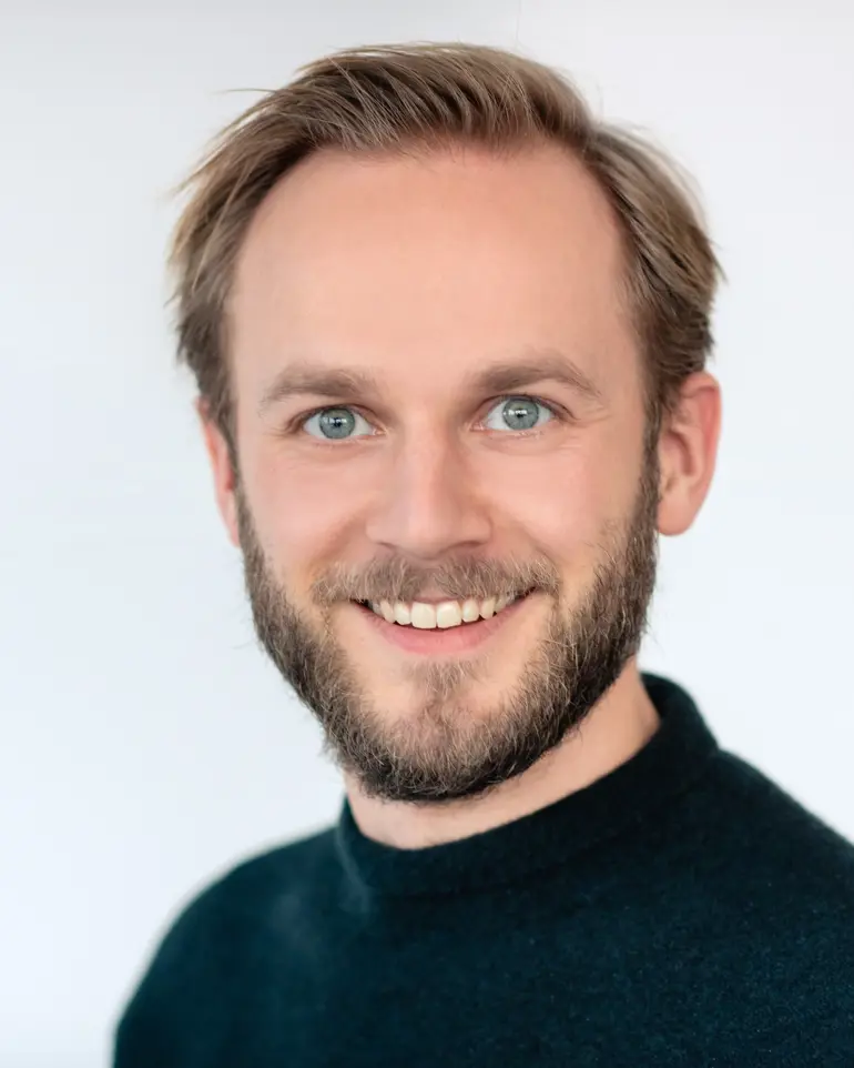 En mann med skjegg som smiler