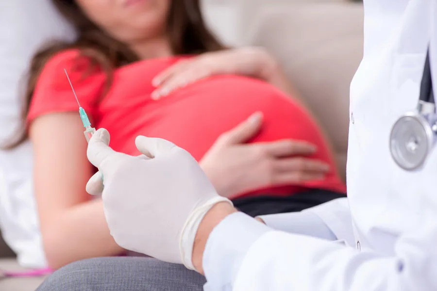 Gravid kvinne får sprøyte av lege