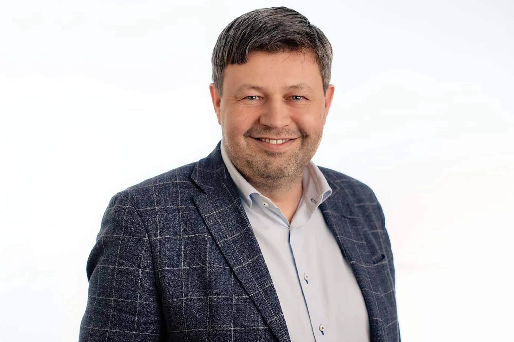 En mann som smiler til kameraet