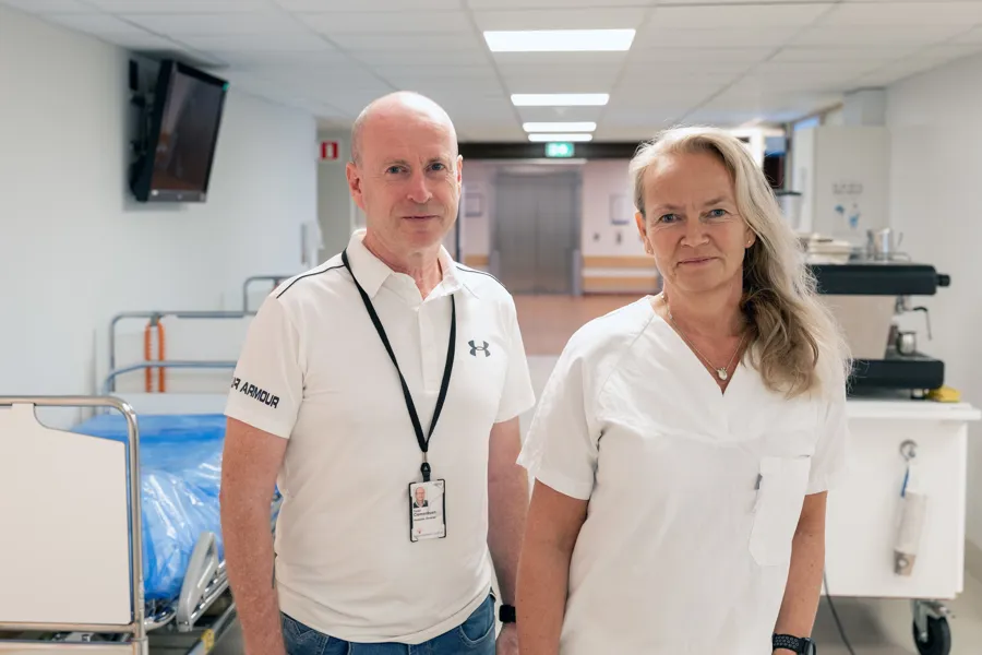 En mann i sivile klær og en kvinnelige overlege i en sykehusgang
