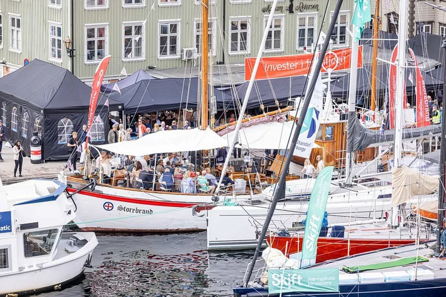En gruppe båter er parkert ved siden av en elv