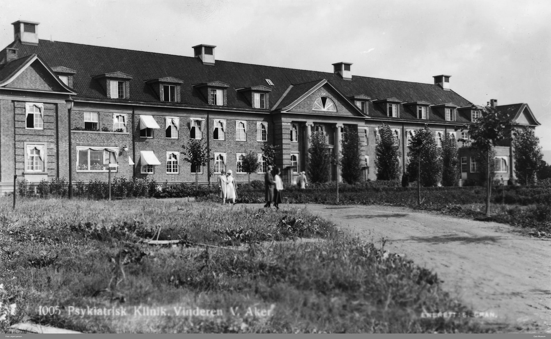 Et par personer som står foran et stort hus