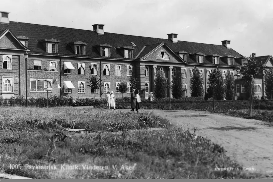 Et par personer som står foran et stort hus