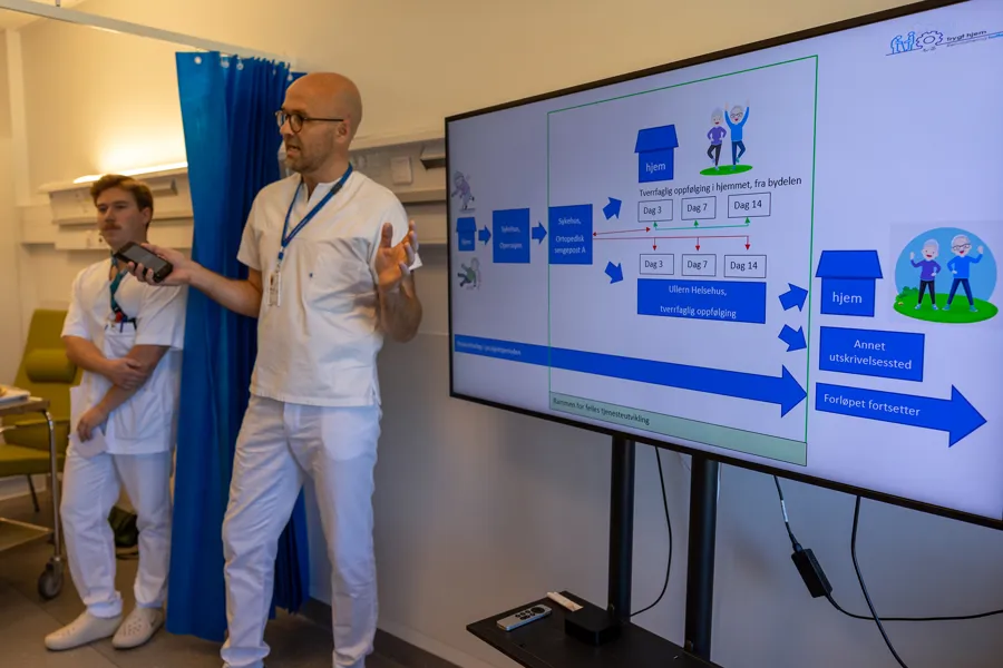 En mann og en kvinne som står foran en skjerm