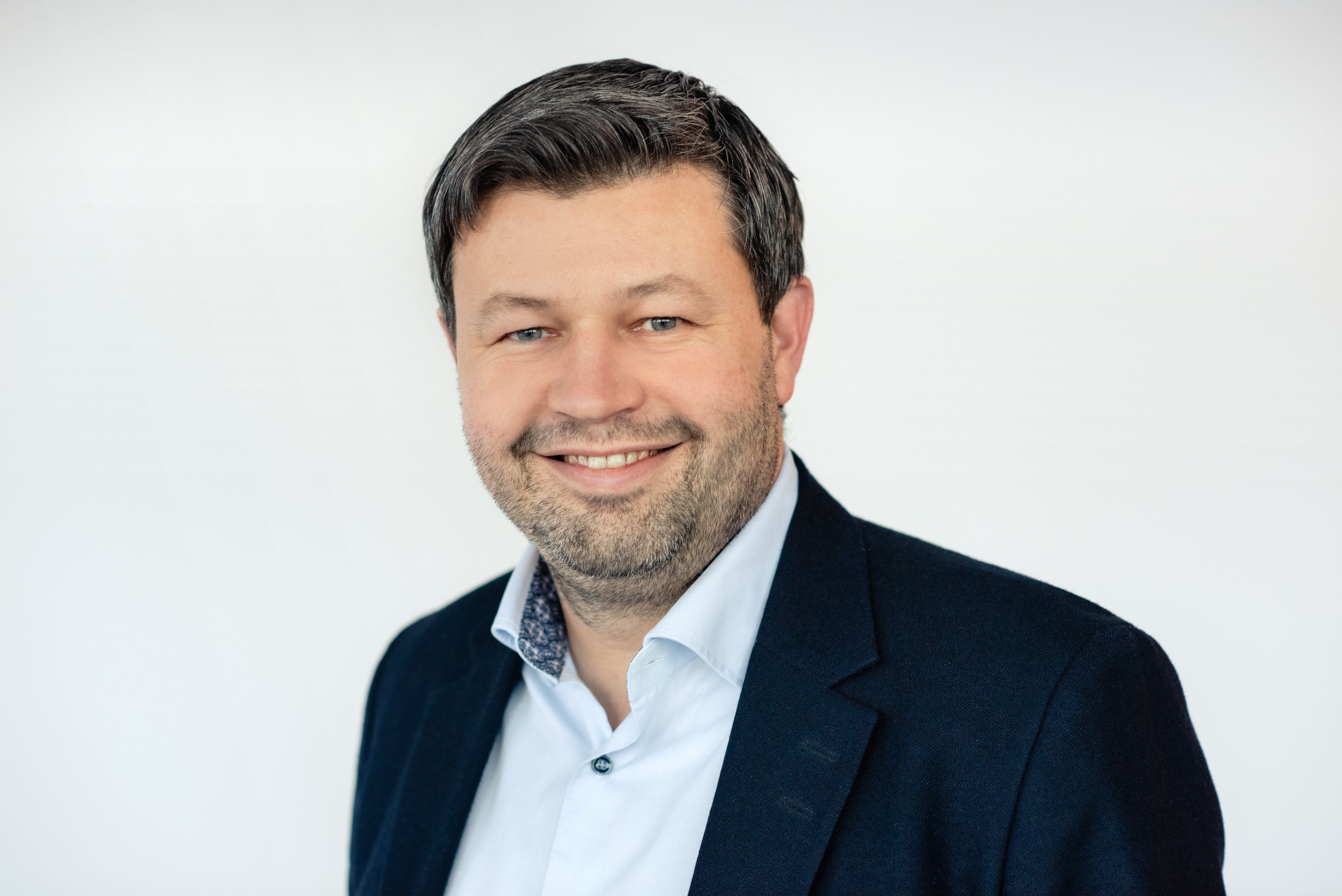En mann som smiler til kameraet