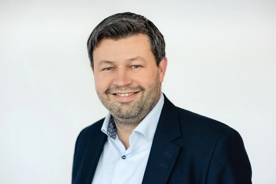 En mann som smiler til kameraet