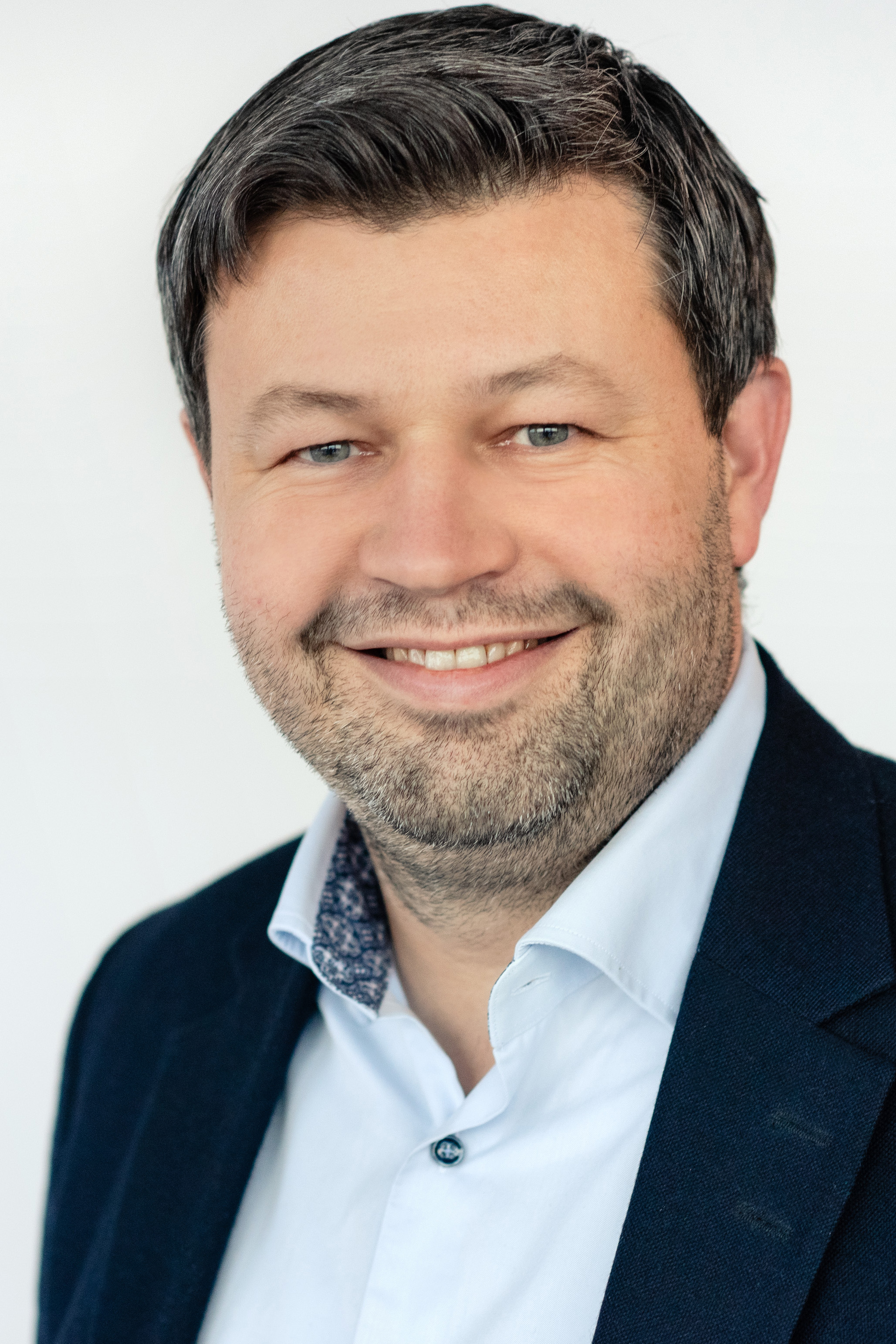 En mann som smiler til kameraet