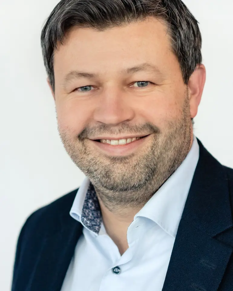 En mann som smiler til kameraet