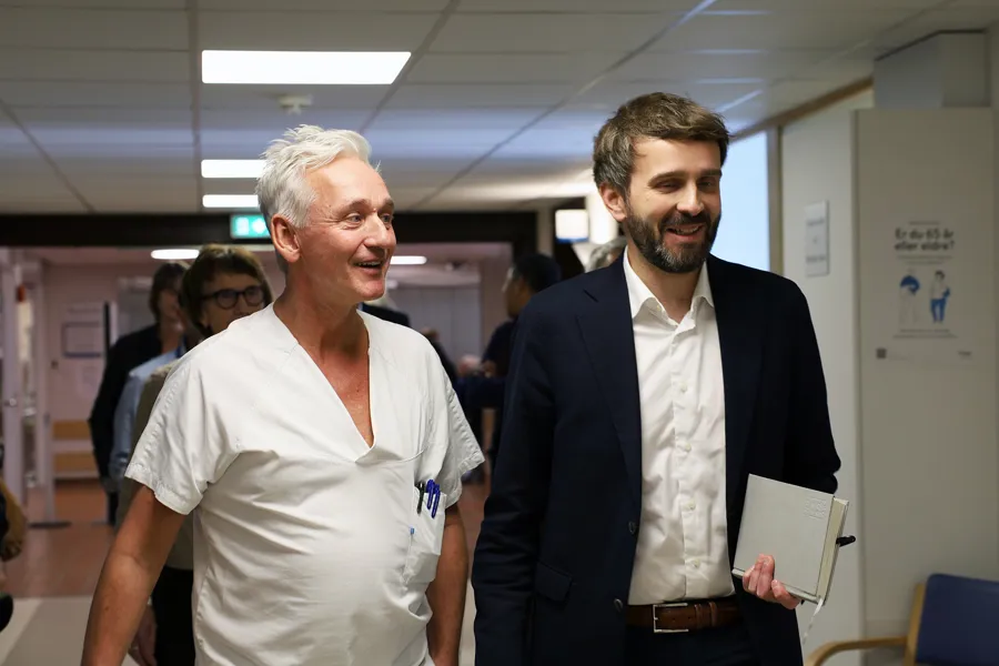 En mann som holder et papir ved siden av en mann som holder et papir