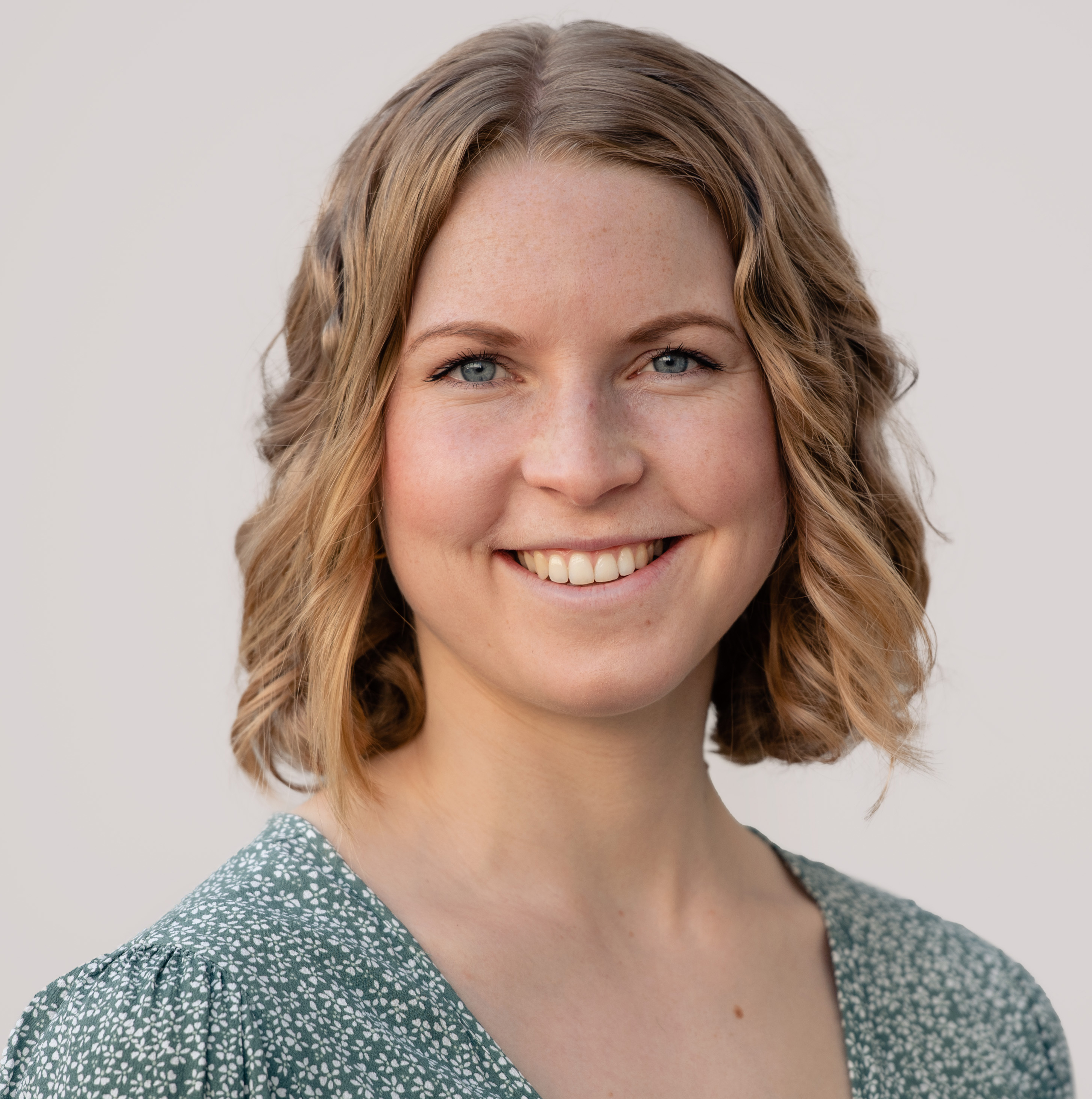 En kvinne som smiler til kameraet
