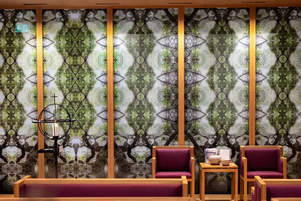 A room with a table chairs and a window with trees outside