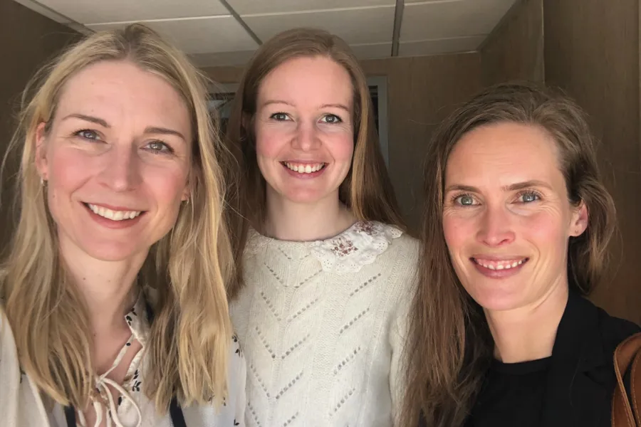 Tre damer som smiler bredt