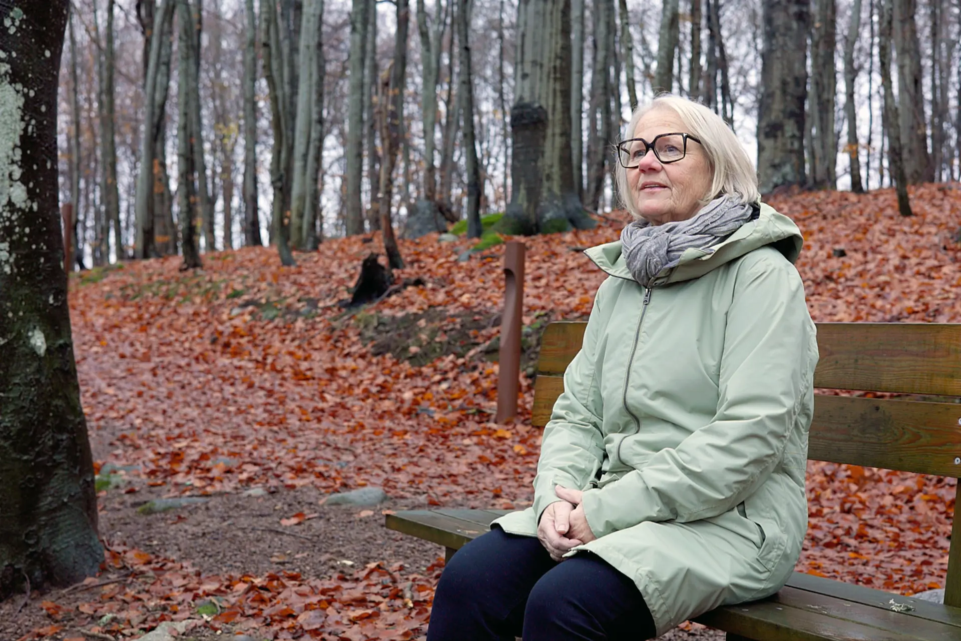 Dame med briller som sitter på en benk