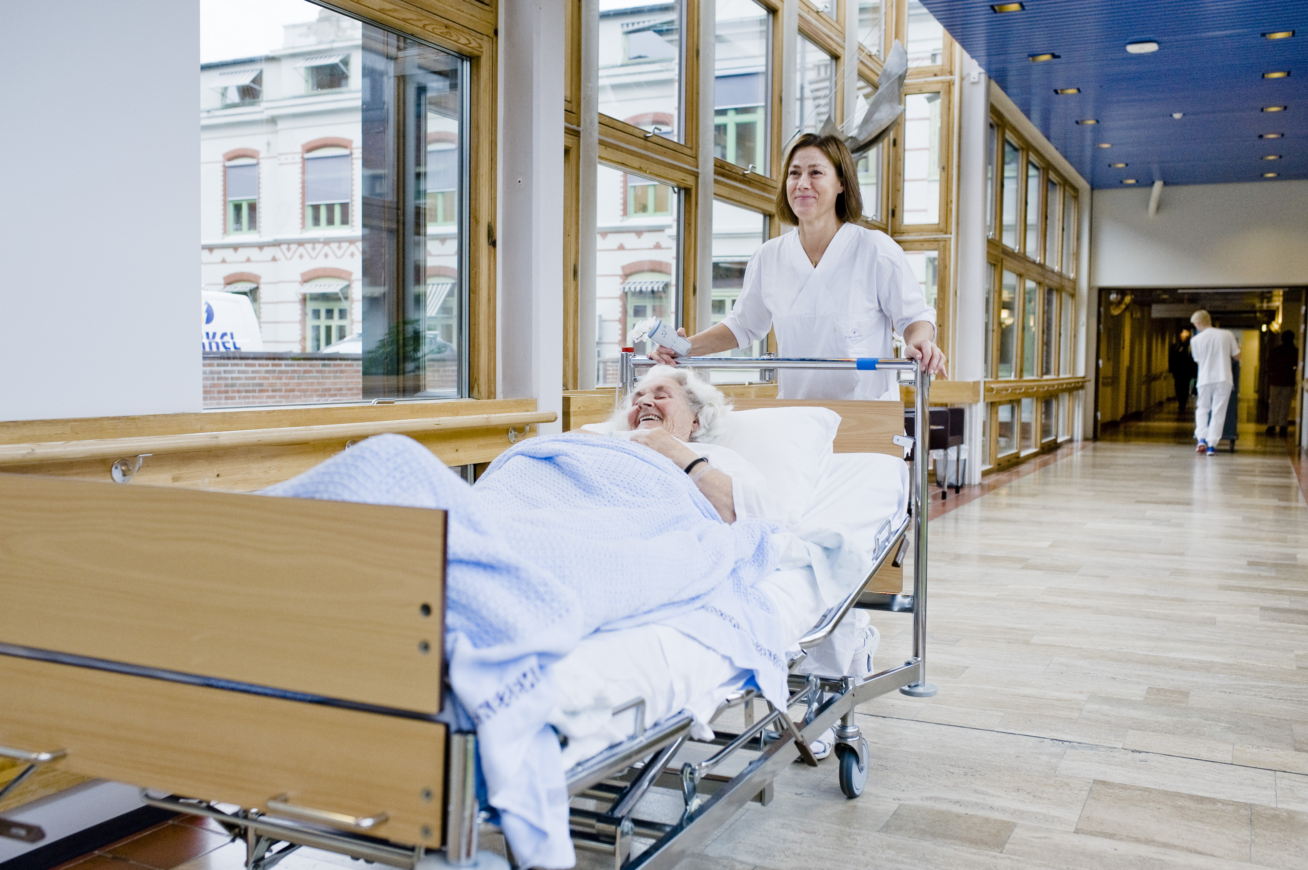 Portør som triller seng med pasient