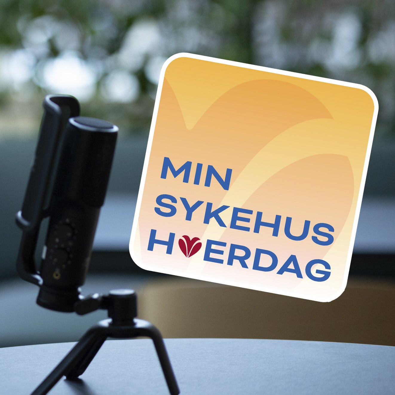 Mikrofon som står på et bord og innklipt Min sykehushverdag logo