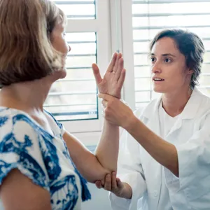 Fysioterapeut som sjekker armen til en pasient