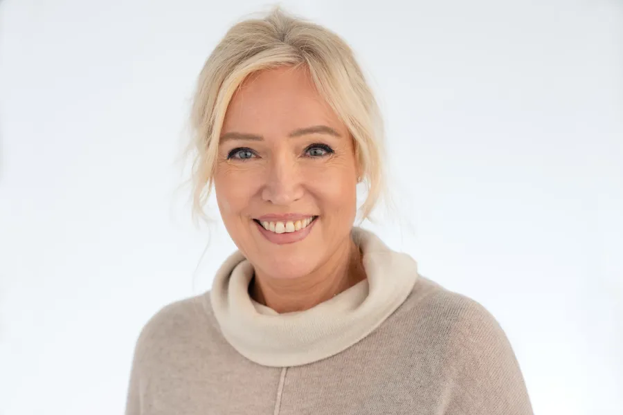 En kvinne som smiler til kameraet