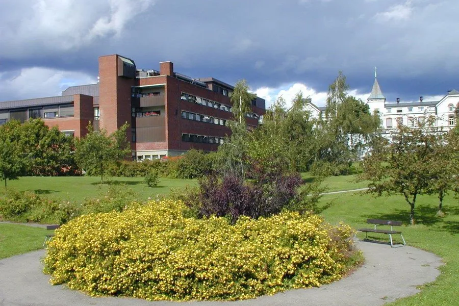 En stor bygning med en hage foran seg