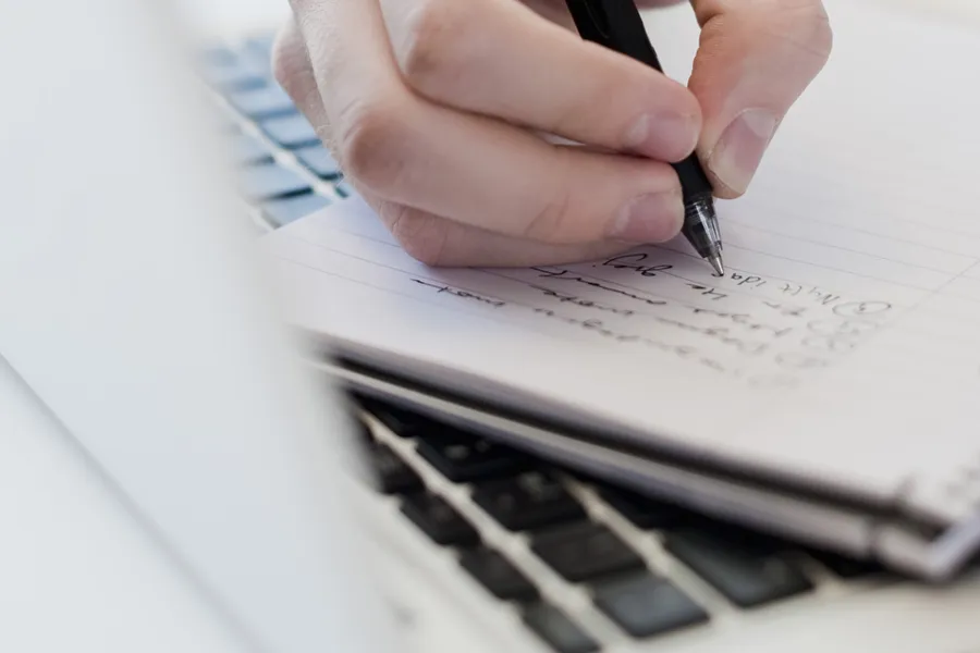 A person writing on a piece of paper