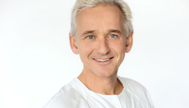 En mann som smiler til kameraet