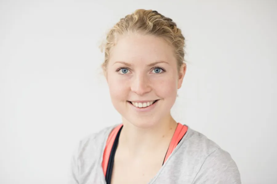 En kvinne som smiler til kameraet