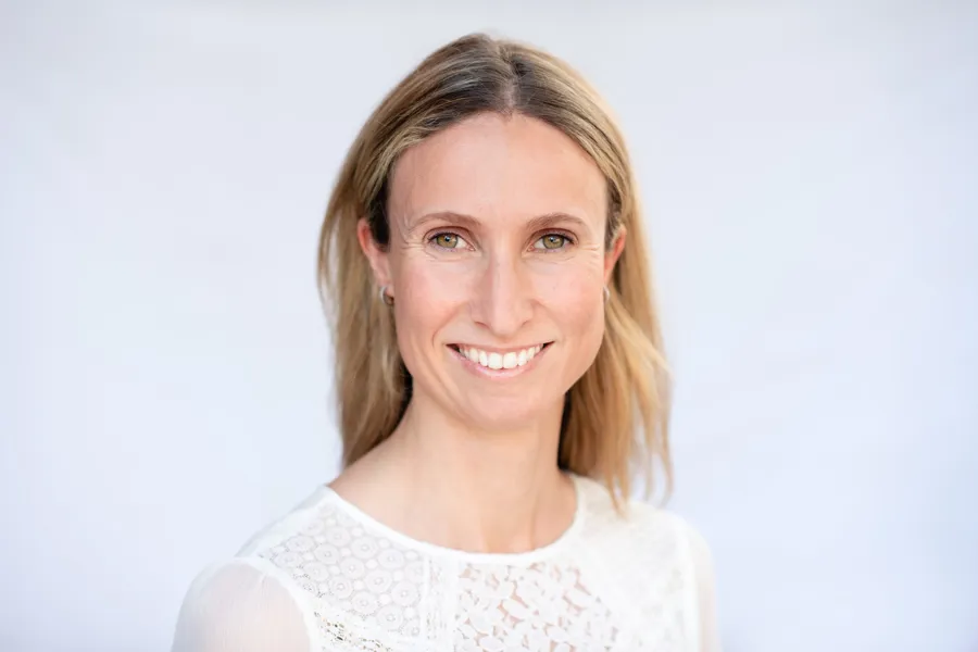 En kvinne som smiler til kameraet