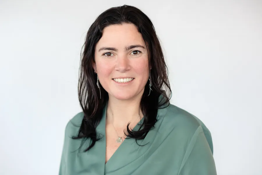 En kvinne som smiler til kameraet