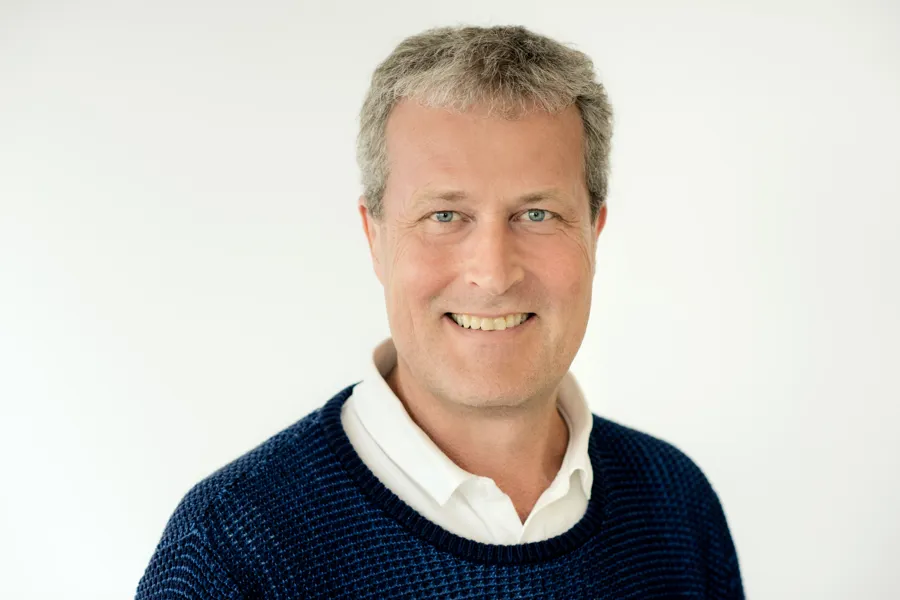 En mann som smiler til kameraet